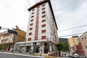 a tall building on the corner of a street at Apart Budapest - Conforto na melhor Rua de Águas de Lindóia in Águas de Lindóia