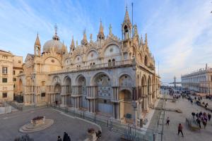 a large building with people walking in front of it at 286 Piazza San Marco - Relais il Doge in Venice