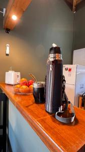 Una botella de agua en la barra de la cocina con fruta en Palotes Sierras Cabañas, en Villa Giardino