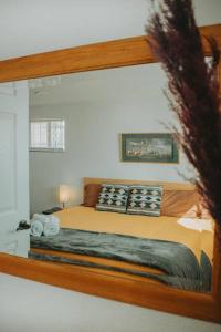 um reflexo de um quarto com uma cama num espelho em Casa Charleston-3BR-2Bath-HOT TUB-Pet Friendly-No Pet Fees! em Albuquerque