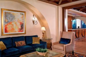 uma sala de estar com um sofá azul e uma cadeira em JW Marriott Las Vegas Resort and Spa em Las Vegas