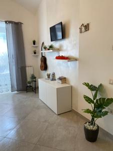 a living room with a white cabinet and a plant at Casa Major in Maiori