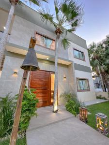 una casa con delle palme davanti di Casa do Sino - Casa de família nos Lençóis Maranhenses! a Barreirinhas