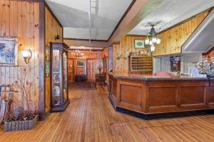 una sala con paredes de madera y un bar en The Pines Inn, en Lake Placid