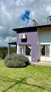 un edificio púrpura con aire acondicionado en Palotes Sierras Apart en Villa Giardino