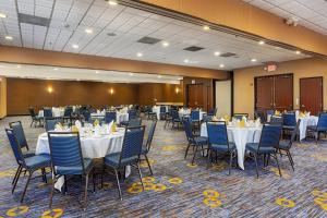 um salão de banquetes com mesas brancas e cadeiras azuis em Courtyard Fairfield Napa Valley Area em Fairfield