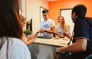 un grupo de personas de pie frente a un espejo en Nate's Place Backpackers Sydney en Sídney