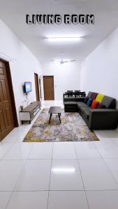 een woonkamer met een bank en een salontafel bij HomeSTAY PANGSAPURI SAMUDERA SERI MANJUNG LUMUT in Seri Manjung