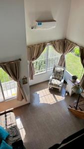 sala de estar con silla y ventana en Palotes Sierras Apart en Villa Giardino