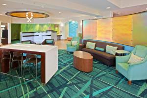 a lobby of a hotel with a bar and chairs at Springhill Suites by Marriott Chicago Schaumburg/Woodfield Mall in Schaumburg