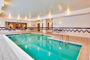 a pool in a hotel with tables and chairs at Springhill Suites by Marriott Chicago Schaumburg/Woodfield Mall in Schaumburg