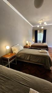 um quarto com 2 camas e uma mesa com 2 candeeiros em El Cerquero, Casa de Huéspedes em San Salvador de Jujuy