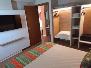 a room with a bedroom with a bed and a tv at Hot Beach Suites Olimpia Resort in Olímpia +15 photos