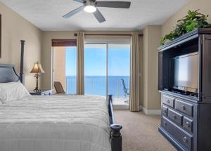 - une chambre avec un lit, une télévision et un balcon dans l'établissement Treasure Island 2102 Beach Front, à Panama City Beach