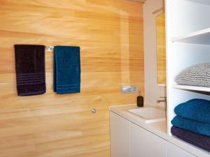 a bathroom with blue towels on a wooden wall at Eco-friendly detached tiny house in the Black Forest on huge property 