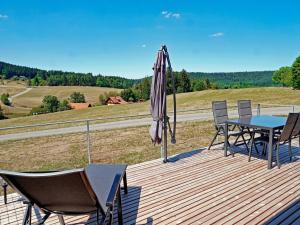 a wooden deck with a table and an umbrella at Eco-friendly detached tiny house in the Black Forest on huge property 