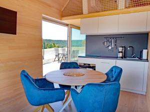 a kitchen with a wooden table and blue chairs at Eco-friendly detached tiny house in the Black Forest on huge property 