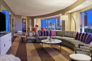 a living room with a couch and a tv at Renaissance Las Vegas Hotel in Las Vegas