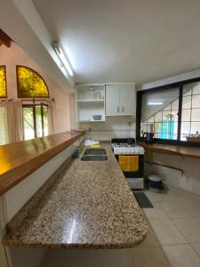 uma cozinha com armários brancos e uma bancada em HUILEN REST em Luján de Cuyo