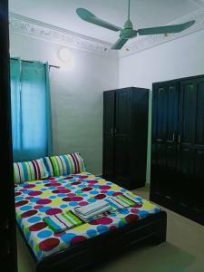 una camera con letto e ventilatore a soffitto di Globe-trotter vision B a Cotonou