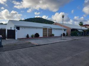 a white building with a parking lot next to a street at Vacances martinique in Sainte-Anne