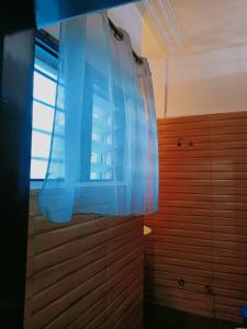 a bedroom with a window and a blue curtain at Globe-trotter vision B in Cotonou