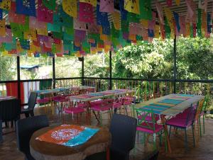 d'une terrasse avec des tables, des chaises et des drapeaux colorés. dans l'établissement La Flor de Jalisco, à Calarcá