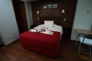 Una habitación de hotel con una cama con toallas. en Kapac Inn Hotel, en Cusco
