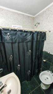 uma casa de banho com uma cortina de chuveiro preta e um lavatório. em La Mar em Mar de Ajó