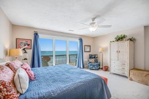 een slaapkamer met een blauw bed en een balkon bij Shore Sensation in Surf City