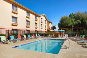 a swimming pool with chairs and a hotel at TownePlace Suites Tempe at Arizona Mills Mall in Tempe