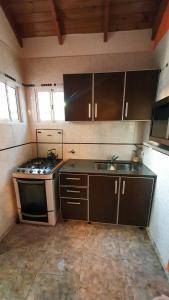 a small kitchen with a stove and a sink at La Mar in Mar de Ajó