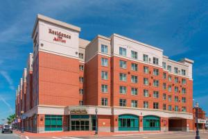 a large red brick building on a city street at Residence Inn by Marriott Moncton in Moncton