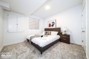 a bedroom with a bed and a dresser and a window at *NEW* Modern Suite King Bed! Netflix! Sleeps 4! in Edmonton