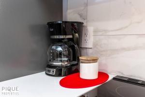 a coffee maker sitting on a counter with a red coaster at *NEW* Modern Suite King Bed! Netflix! Sleeps 4! in Edmonton +21 photos