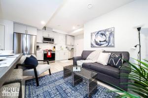 a living room with a couch and a kitchen at *NEW* Modern Suite King Bed! Netflix! Sleeps 4! in Edmonton