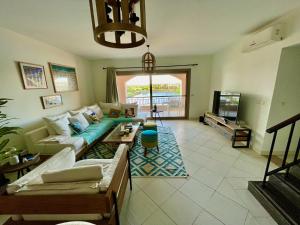 a living room with a couch and a tv at The Penthouse in Marassi in El Alamein