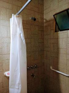 y baño con ducha con cortina blanca. en Descanso en casa de familia en Salta