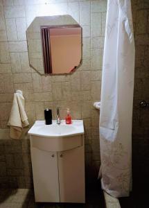 y baño con lavabo y espejo. en Descanso en casa de familia en Salta