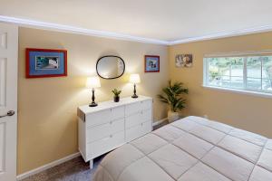 a bedroom with a white bed and a mirror at Jefferson Joy in Eugene