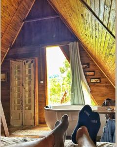 a person with their feet up in a room with a tub at Chalés do Palácio in Campos do Jordão