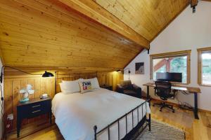 Ponderosa Log Cabin في كلي إلوم: غرفة نوم بسرير وسقف خشبي