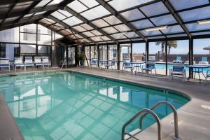a swimming pool with chairs and tables in a building at 1104 Starfish Room by Atlantic Towers in Carolina Beach +13 photos