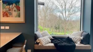 un sofá con una manta delante de una ventana en Silvan Forest Pod 2, en Richmond