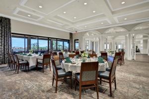 a dining room with tables and chairs and windows at Vasari Country Club #201 - Toscana Treasure in Bonita Springs