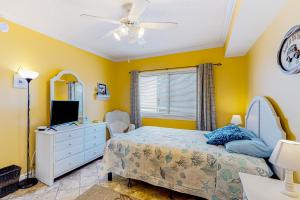 um quarto com paredes amarelas, uma cama e uma ventoinha de tecto em Bahia Vista I 204 em Ocean City