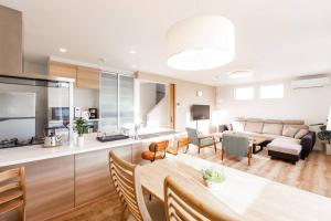 札幌的住宿－THE SUN，厨房以及带桌子和沙发的客厅。