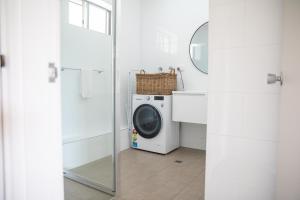 a washing machine in a bathroom with a mirror at Harriet House Tumut in Tumut