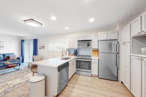 eine Küche mit weißen Schränken und Küchengeräten aus Edelstahl in der Unterkunft Gulf Terrace #256 in Destin