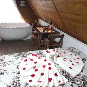 a bed in a room with a tub and a table at Chalés do Palácio in Campos do Jordão